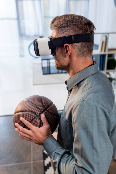 businessman wearing virtual reality headset and holding basketball - Fotó, kép
