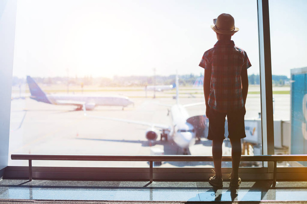 Junge schaut sich Flugzeuge am Flughafen an - Foto, Bild