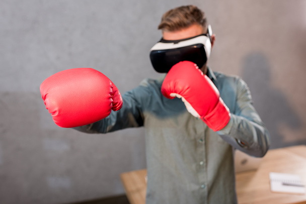 ビジネスマンのオフィスに仮想現実のヘッドセットを着用しながらボクシングの選択と集中 - 写真・画像