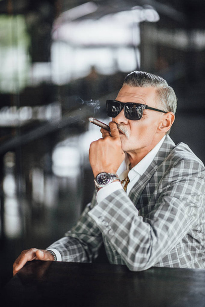 man smoking cigarette, focus on foreground - Foto, afbeelding