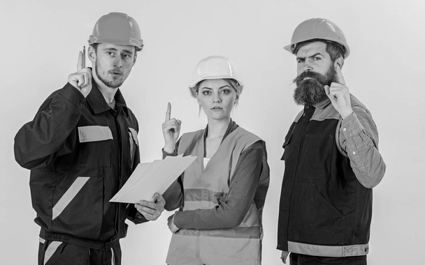 Men in hard hats, uniform and woman. Builder and engineer - 写真・画像