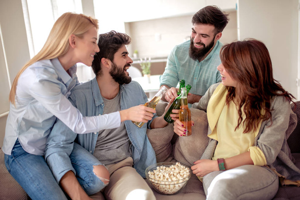 Gelukkige vrienden die voetbal kijken op tv en thuis de overwinning vieren.Vriendschap, sport en entertainment concept. - Foto, afbeelding