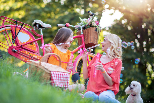 Mother and daughter having picnic in the park,enjoying together. - Photo, Image