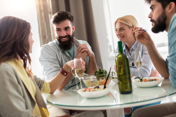 Grupa przyjaciół świętować z alkoholu i jedzenie na stół. - Zdjęcie, obraz