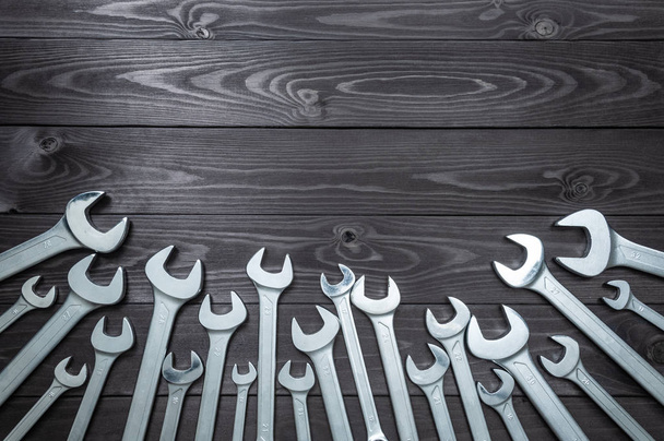 set of chromed wrenches on a dark wooden workbench. top view, copy space - Foto, Imagem