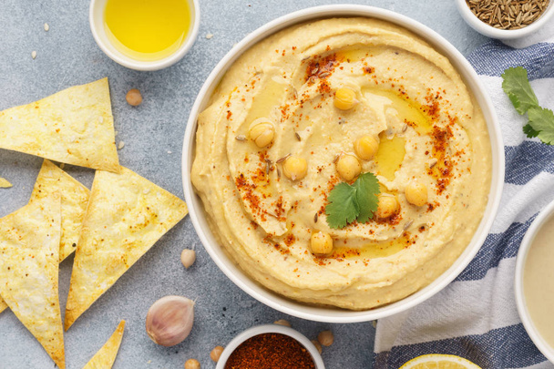 Hummus bowl served with tortilla chips. Middle eastern food. - Foto, Bild