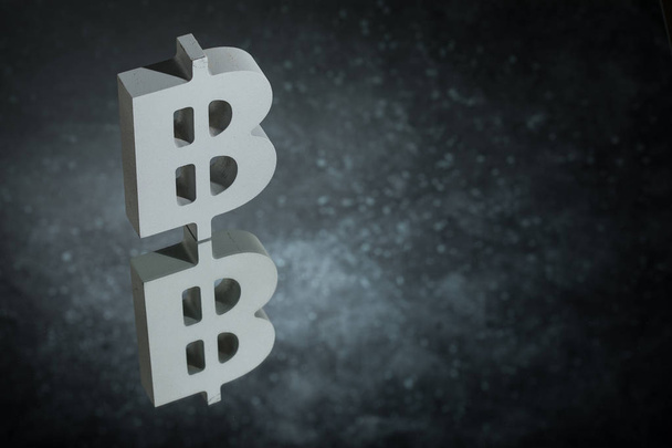 Symbol waluty Bitcoin lub znak z odbicie lustrzane na ciemnym tle zakurzone - Zdjęcie, obraz