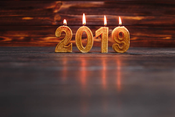 golden candles in form of numbers 2019 on wooden background - Fotoğraf, Görsel