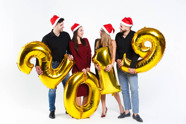 Portrait of group of friends celebrating New Year, standing with balloons with golden numbers in 2019 isolated on white background - Fotó, kép