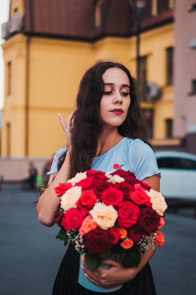 Happy hezká dívka drží současné kytice s růží  - Fotografie, Obrázek