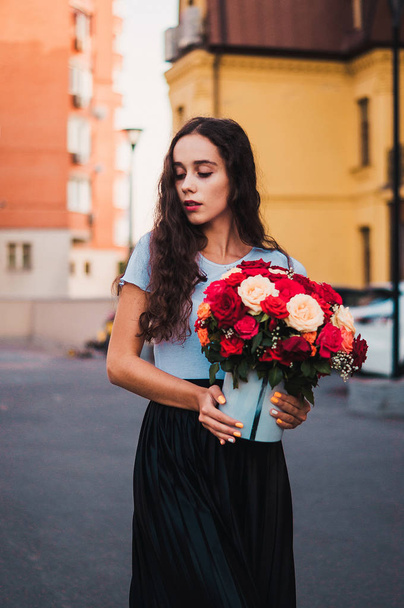 Happy pretty girl holding present of bouquet with roses  - Zdjęcie, obraz