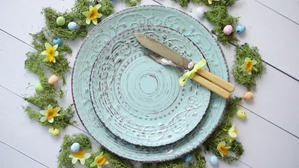 Apparecchiatura della tavola pasquale con fiori e uova. Piatti decorativi in ceramica vuoti
 - Filmati, video