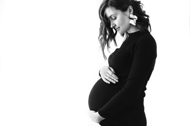 Fashionable pregnant mom, hugging belly. Stylish Motherhood conc - Photo, Image