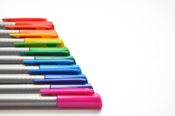 Reeks van kleurrijke pennen, precies liggen diagonaal in de linker kant van de close-up foto, met copyspace - Foto, afbeelding