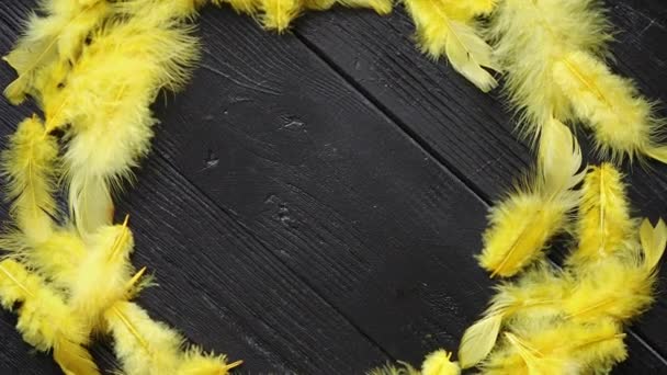 Színes dekoratív húsvéti toll koszorú a fekete fából készült asztal háttere - Felvétel, videó