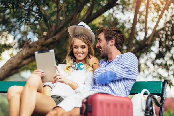 Jeune couple amoureux de touriste assis dans le banc du parc et hav
 - Photo, image