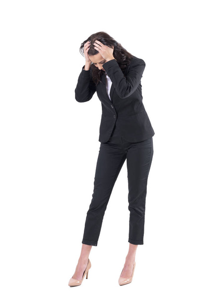 Worried business woman with head in hands looking down searching for something lost. Full body isolated on white background.  - Фото, изображение