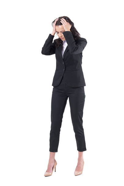 Upset stressed business woman with head in hands looking down in despair. Full body isolated on white background.  - Фото, изображение