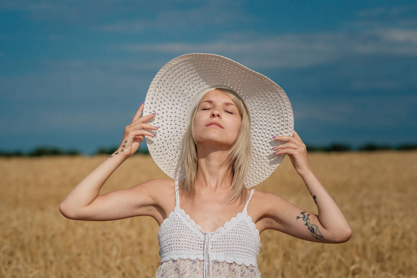 Natur, Sommerferien, Urlaub und Menschen-Konzept - das Gesicht einer glücklich lächelnden Frau oder eines Teenagers mit Hut auf einem Getreidefeld - Foto, Bild