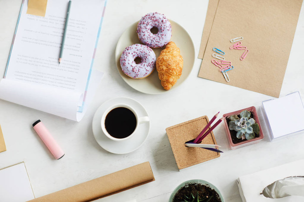 Hintergrund des Büroarbeitsplatzes mit Schreibwaren, Snacks und schwarzem Kaffee - Foto, Bild
