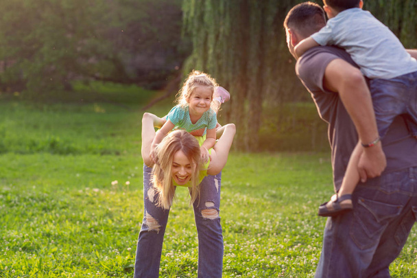 Happy Childhood Perhe reppuselässä lapsensa ja pitää hauskaa yhdessä
 - Valokuva, kuva