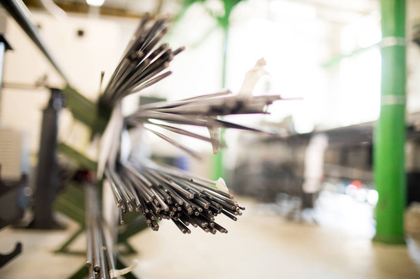 現代の工場で産業使用のために準備された鋼鉄棒の束の端を切る - 写真・画像