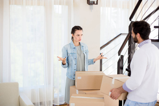 Young couple having conflict about where to put all stuff in boxes in their new house - Photo, Image