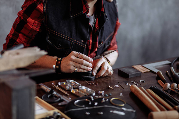 gorgeous creative man flattening and shaping metals and jewelries. - Photo, image