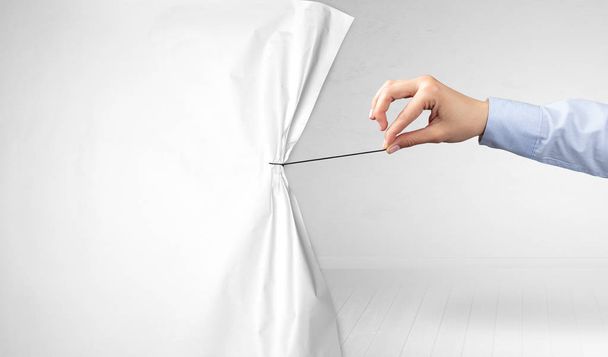 hand pulling white paper curtain - Foto, afbeelding