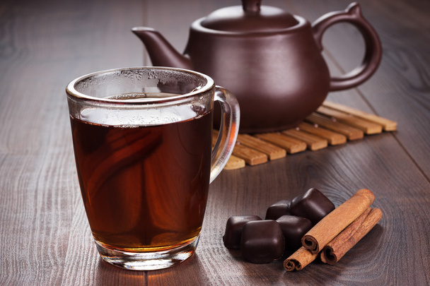 Cup of tea with cinnamon sticks and teapot - Zdjęcie, obraz