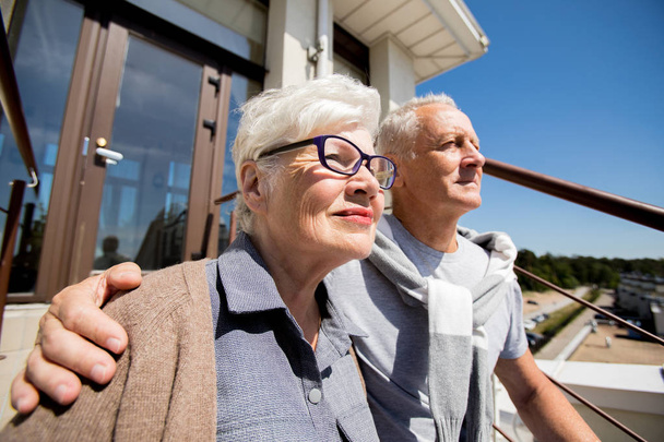 Ritratto di coppia anziana moderna che si abbraccia all'aperto alla luce del sole sorridendo felicemente
 - Foto, immagini