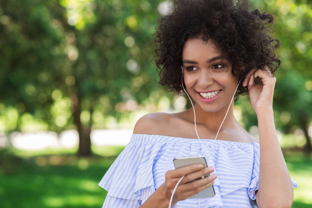 Young african-american girl listening music on smartphone - Photo, image