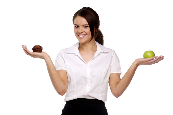 Business woman comparing an apple and cake - Fotó, kép