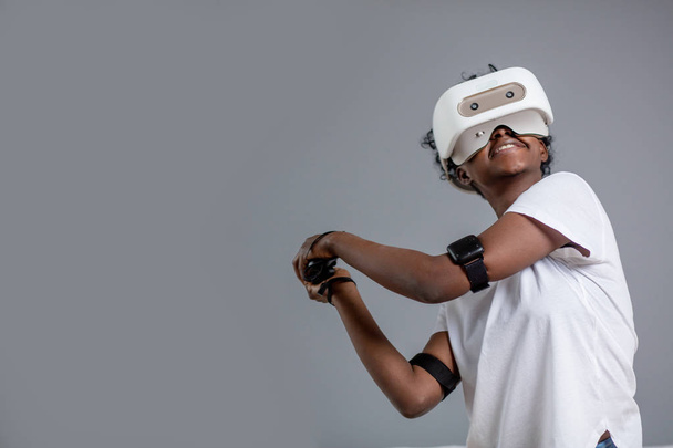 Young african student girl playing with virtual reality glasses. - 写真・画像