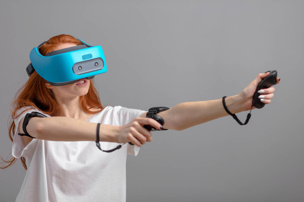 Redhead girl using VR glasses isolated over white. Virtual reality experience - Photo, Image