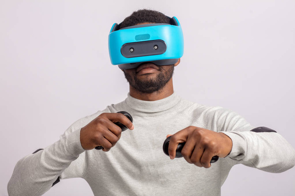 Young african man wearing virtual reality goggles isolated on white background - Valokuva, kuva