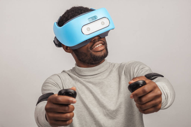 Young african man wearing virtual reality goggles isolated on white background - Φωτογραφία, εικόνα