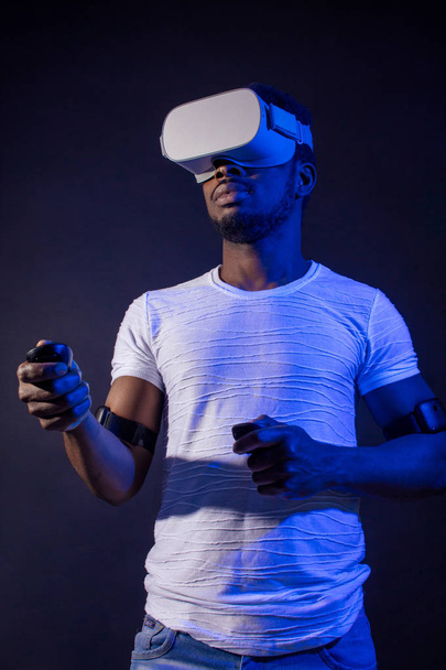 African Man in white, wearing VR Headset on green blue dual color background. - Fotografie, Obrázek
