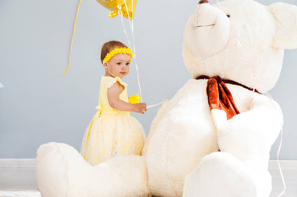 Menina com balões e um grande brinquedo urso branco
 - Foto, Imagem