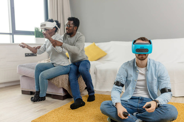 Multiracial group of friends having fun trying on 3D virtual reality goggles. - Valokuva, kuva