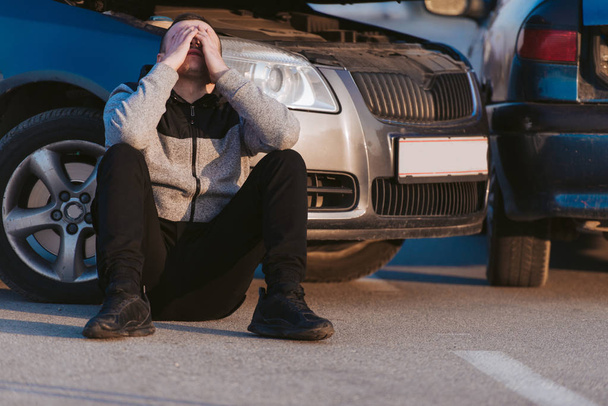 Man sitting front of his damaged car - Photo, Image