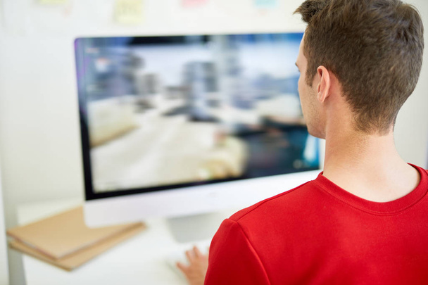 Σχεδιαστής φωτογραφίας κοιτάζοντας την εικόνα στην οθόνη του υπολογιστή ενώ το reαγγίγματα από το χώρο εργασίας - Φωτογραφία, εικόνα