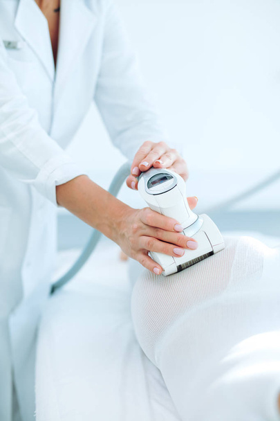 Woman in white suit getting LPG procedure , body contouring treatment in clinic. - Foto, Bild