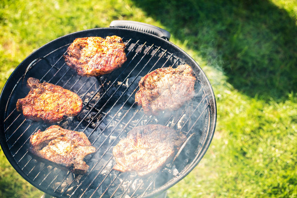 vue grand angle de steaks gastronomiques frais rôtissant sur le barbecue au charbon de bois en plein air
  - Photo, image