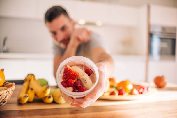 Young caucasian man preparing his healthy smoothie in the mornin - Foto, Imagen