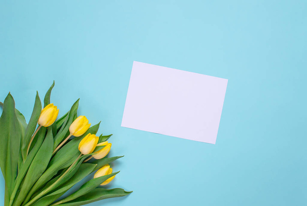 Ramo de tulipanes amarillo, fondo azul, primavera. Concepto del día de Pascua. Vista superior. Copiar espacio. Día de la mujer. Día de la Madre
 - Foto, imagen