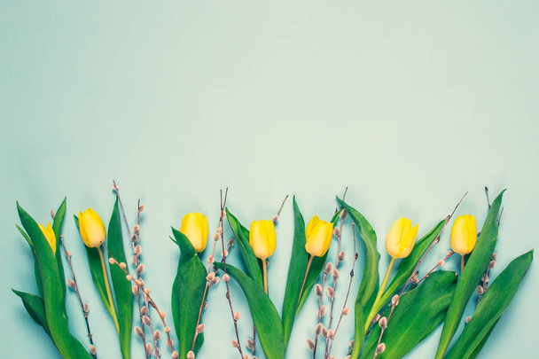 Ramo de tulipanes amarillo, fondo azul, primavera. Concepto del día de Pascua. Vista superior. Copiar espacio. Día de la mujer. Día de la Madre
 - Foto, imagen
