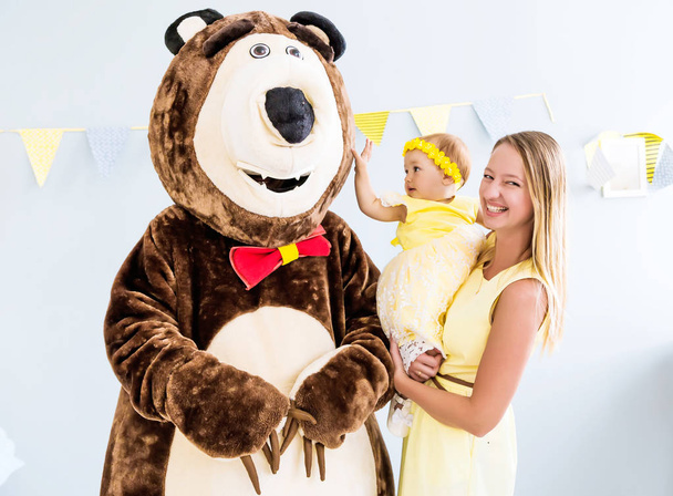 Schauspieler im Bärenkostüm gratuliert einem Mädchen und ihrer Familie zum Geburtstag - Foto, Bild