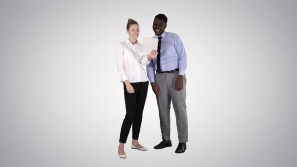 Young caucasian businesswoman and her african colleague making video call with tablet on gradient background. - Footage, Video