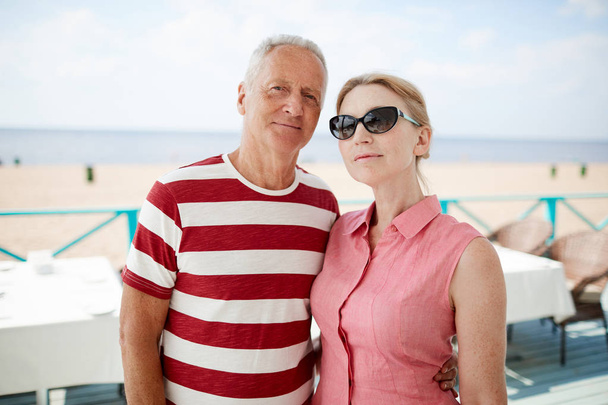 Cariñosa pareja de cónyuges mayores disfrutando del descanso en el resort de verano no muy lejos de la playa
 - Foto, Imagen